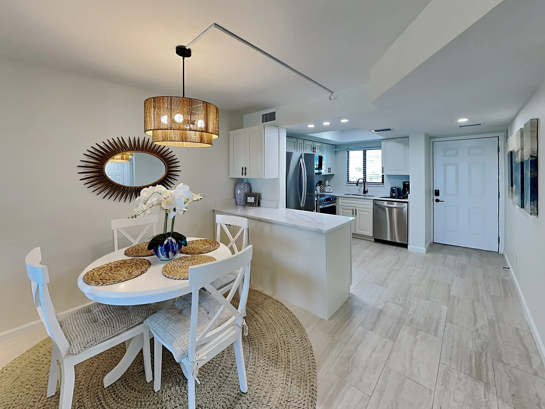 An open dining and kitchen area with a table, island, and white cabinetry.