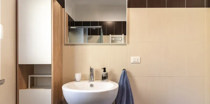 Un baño con lavabo, espejo y toalla.
