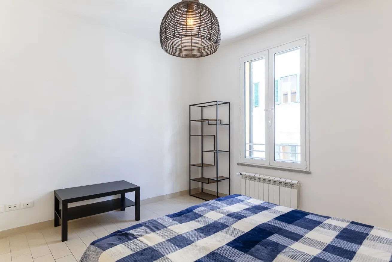 Un dormitorio con una cama cubierta con una manta de cuadros azules y blancos.