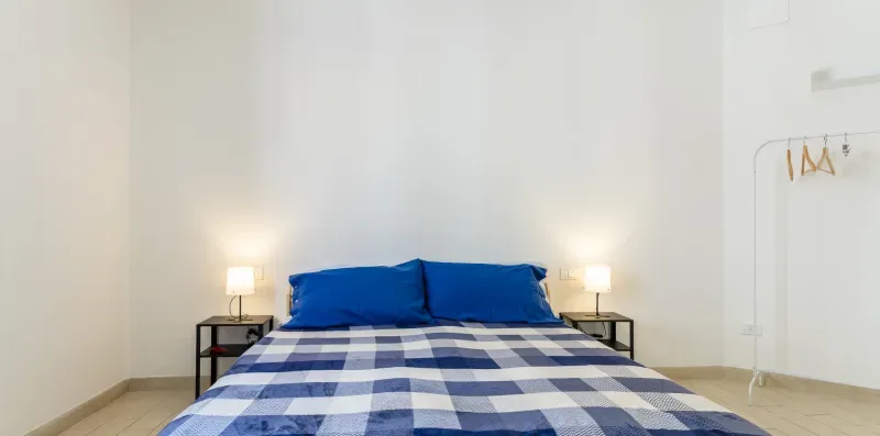 Un dormitorio con una cama vestida con ropa de cuadros azules y blancos.
