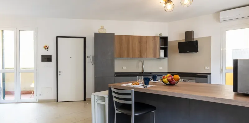 Una cocina luminosa con una isla larga y asientos para comer.
