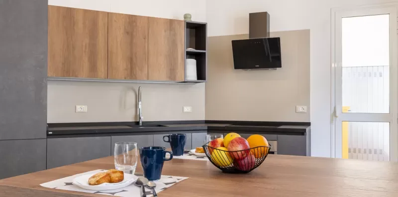 Una cocina con armarios de madera, una encimera y fruta sobre la mesa.