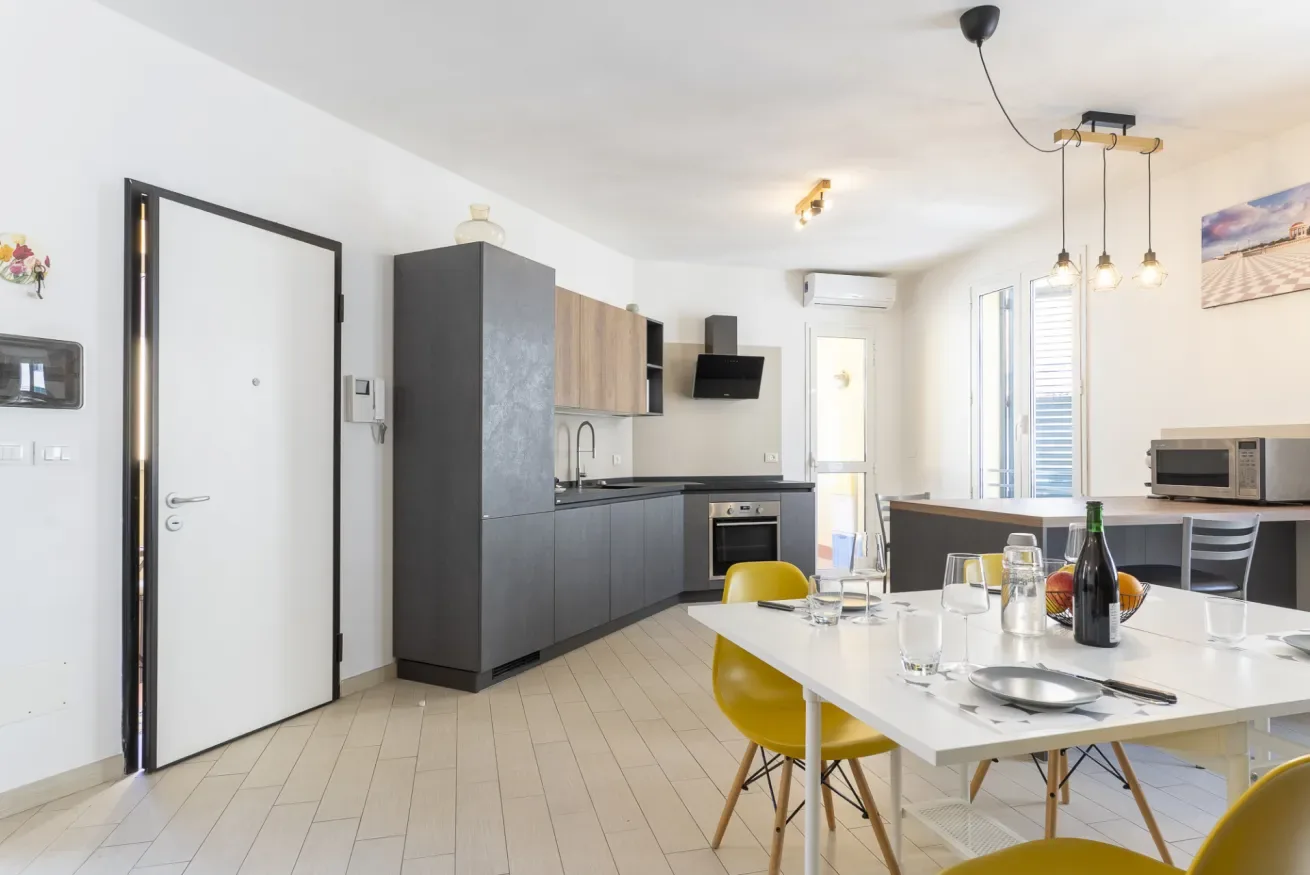 Una cocina y comedor diáfanos y luminosos, con una mesa preparada para comer.