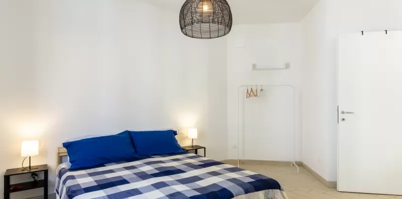 Un dormitorio con una cama cubierta con ropa de cama a cuadros azules y blancos.