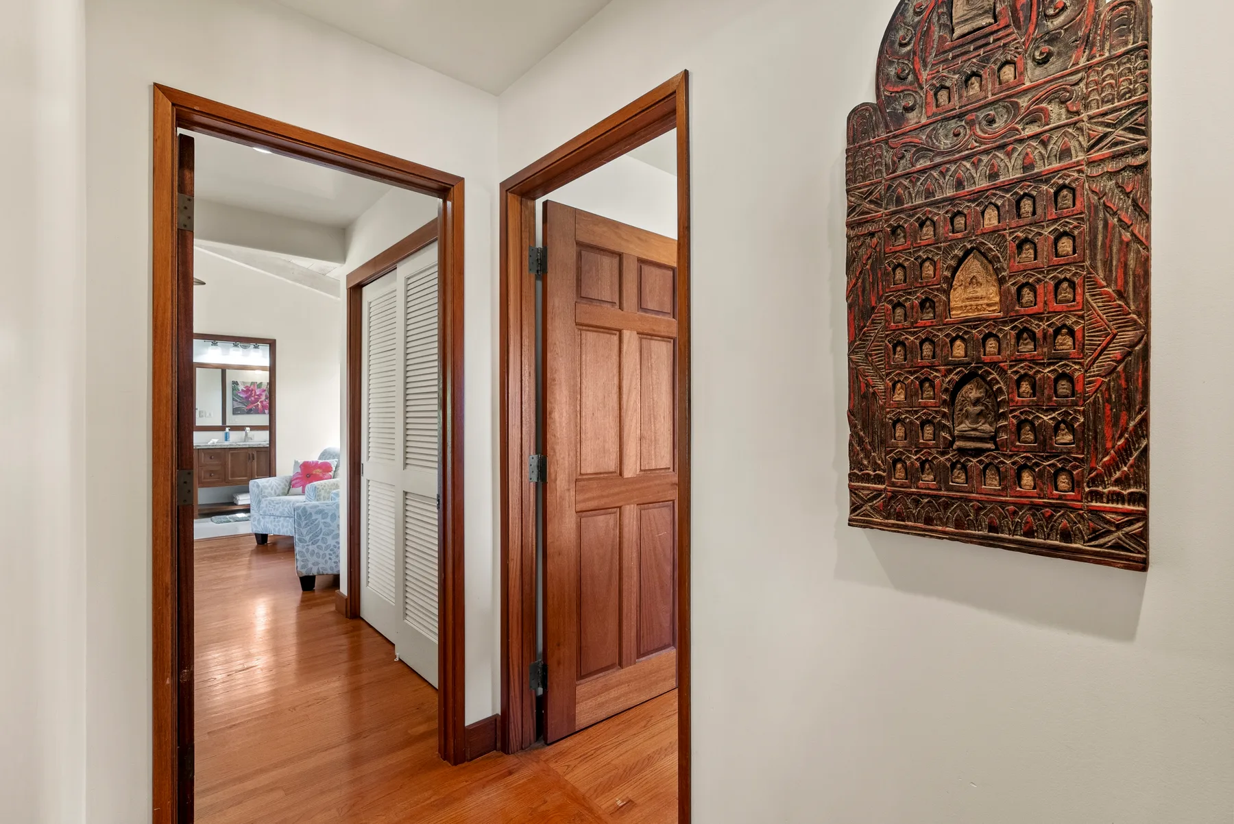 Un pasillo con puertas de madera y un adorno decorativo en la pared.