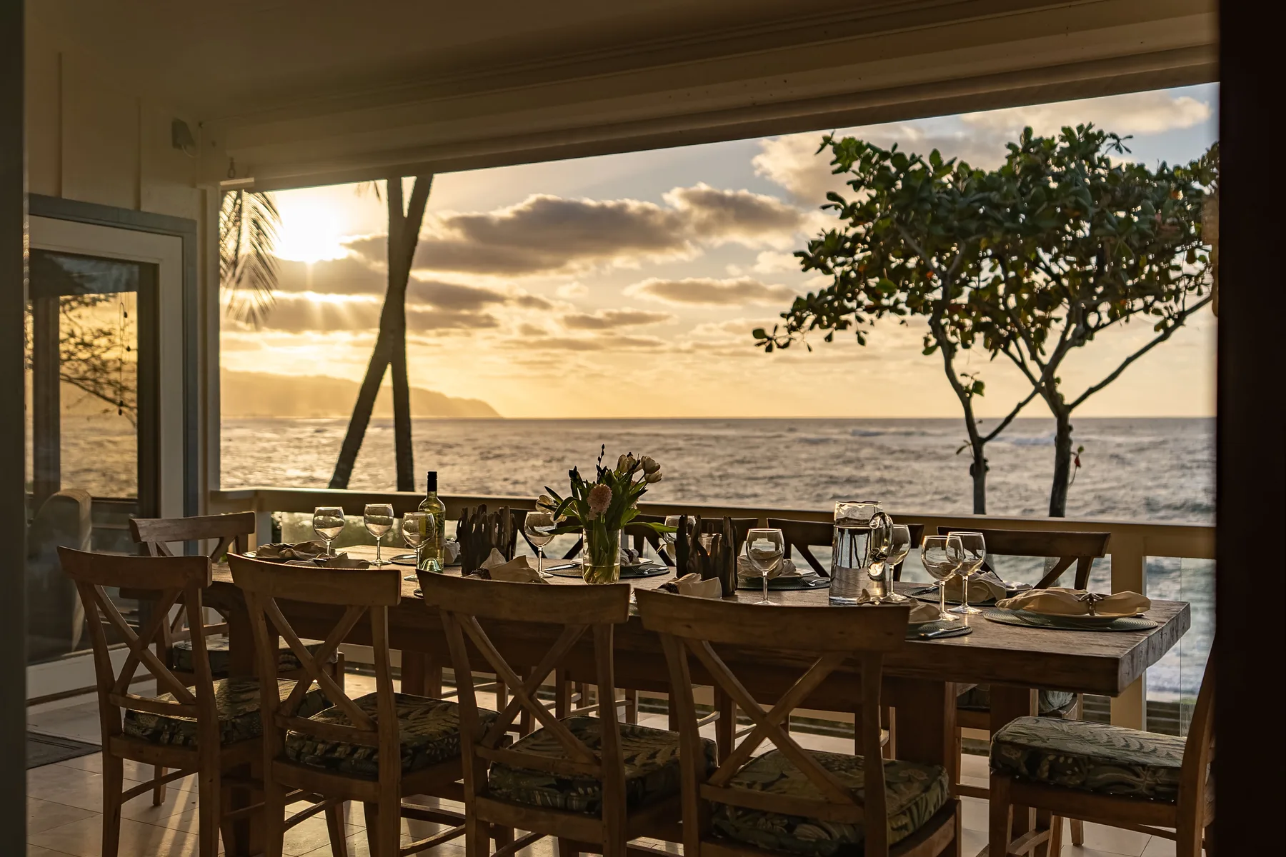 Una zona de comedor al aire libre da al mar al atardecer.