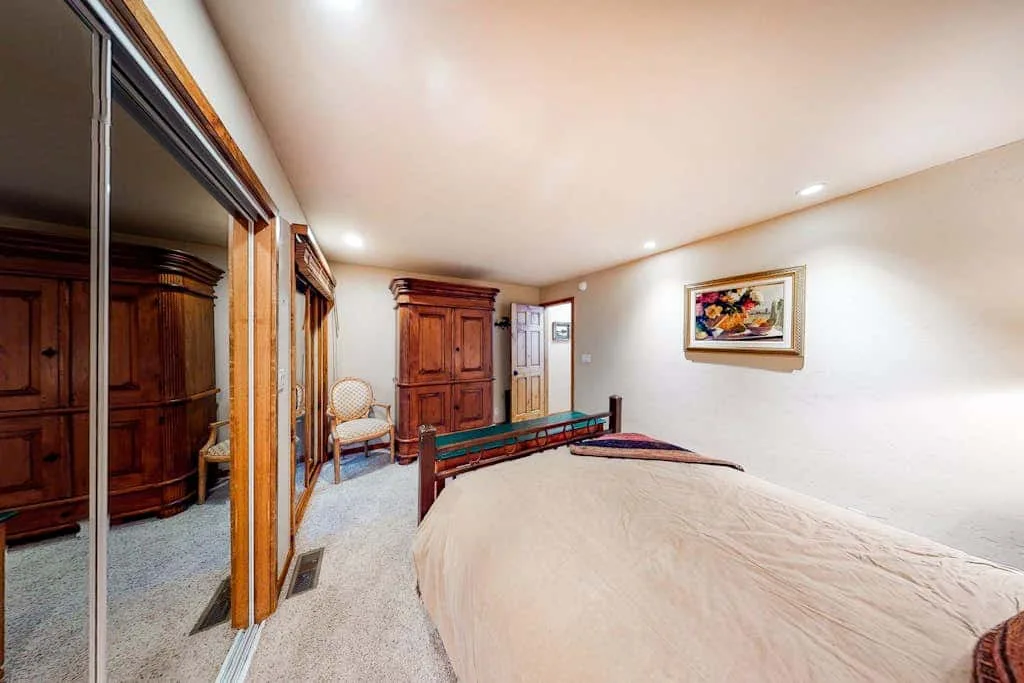 A bedroom with a bed, wooden furnishings, and a framed picture on the wall.