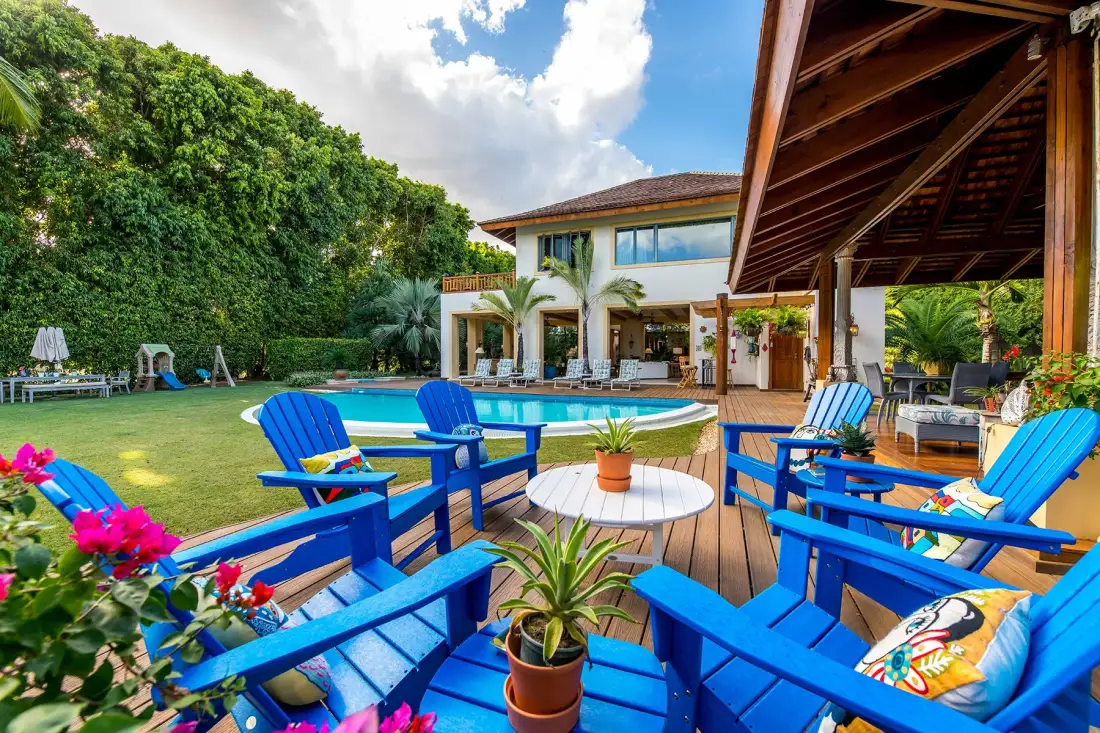 A poolside patio with blue seating and a covered wooden deck.