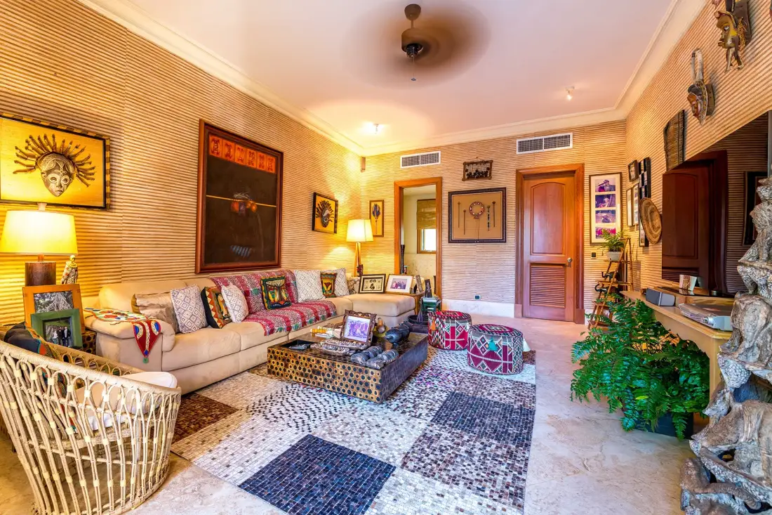 A living room with seating around a low coffee table and colorful patterned rugs.