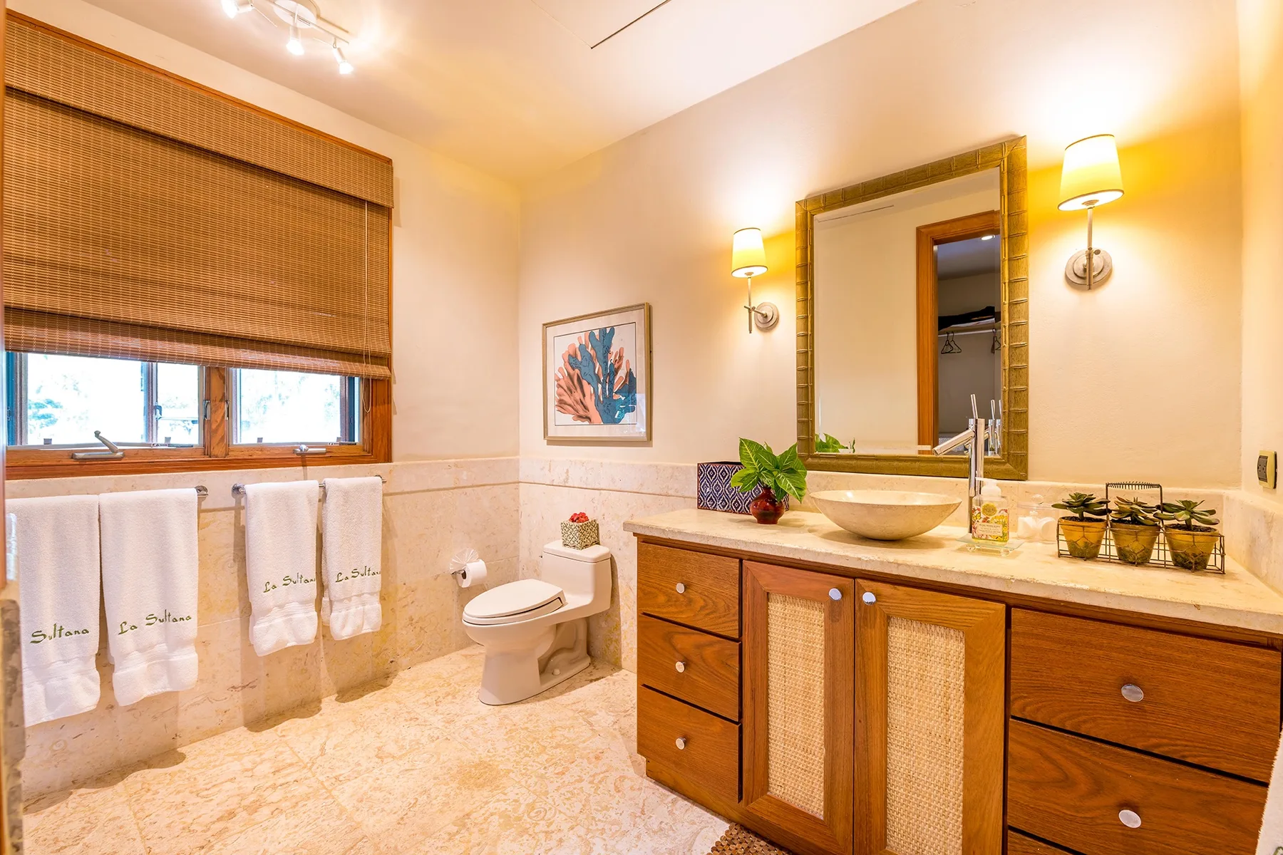 A bathroom with a wooden vanity, a large mirror, and a bathtub area.