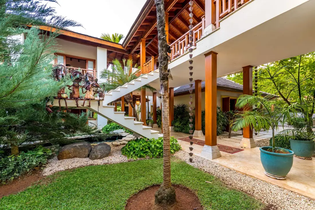 A landscaped courtyard with an exterior staircase and an open-sided upper walkway.