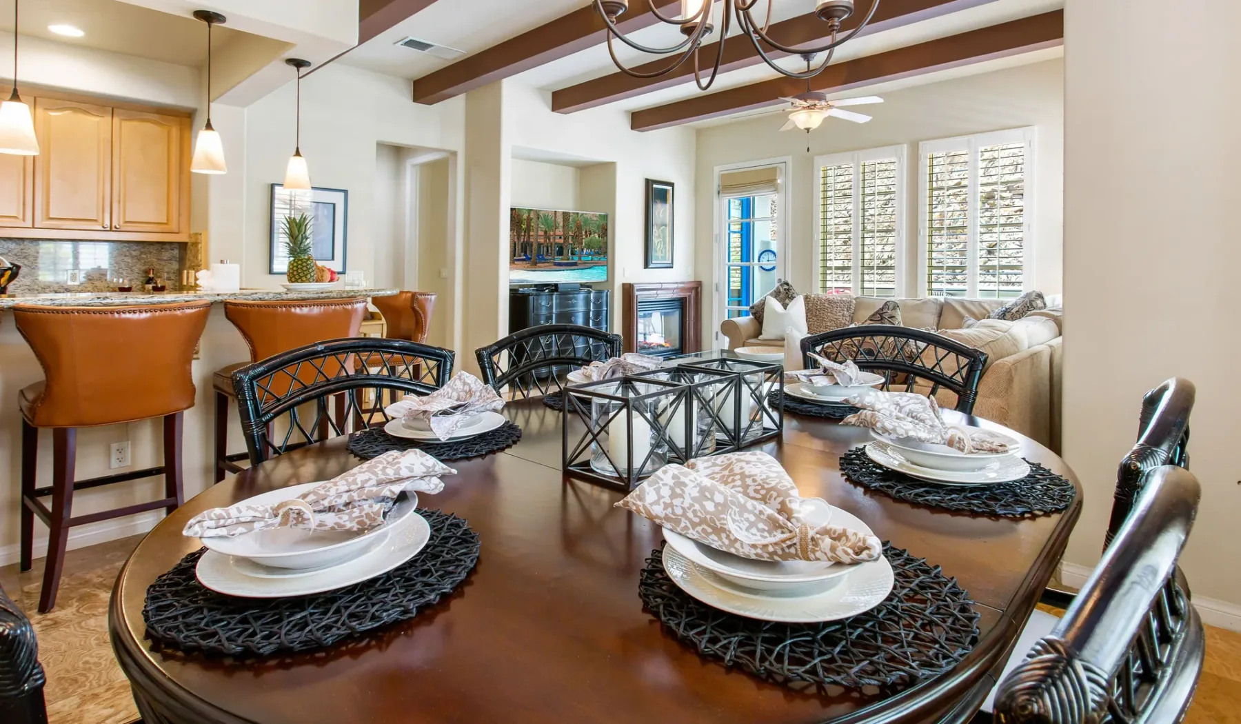 Comedor con una mesa puesta y una cocina abierta al fondo.