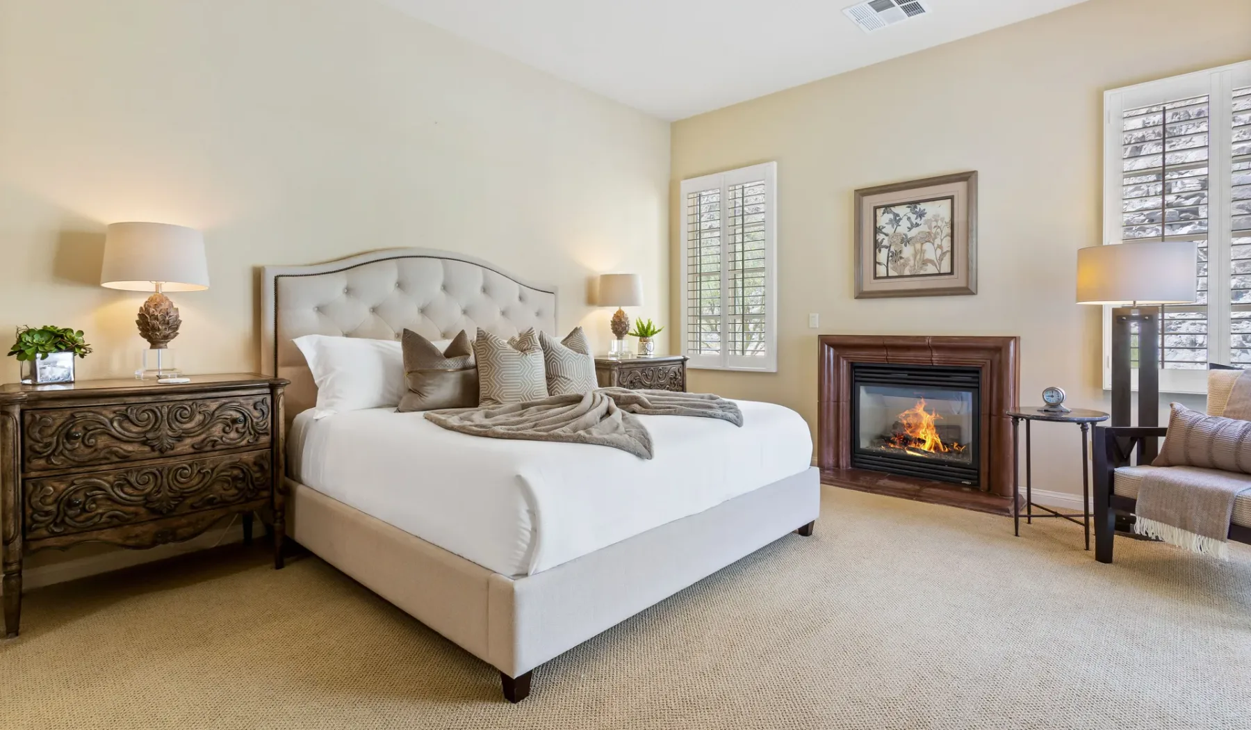 Un dormitorio con una cama grande, muebles auxiliares y una chimenea.