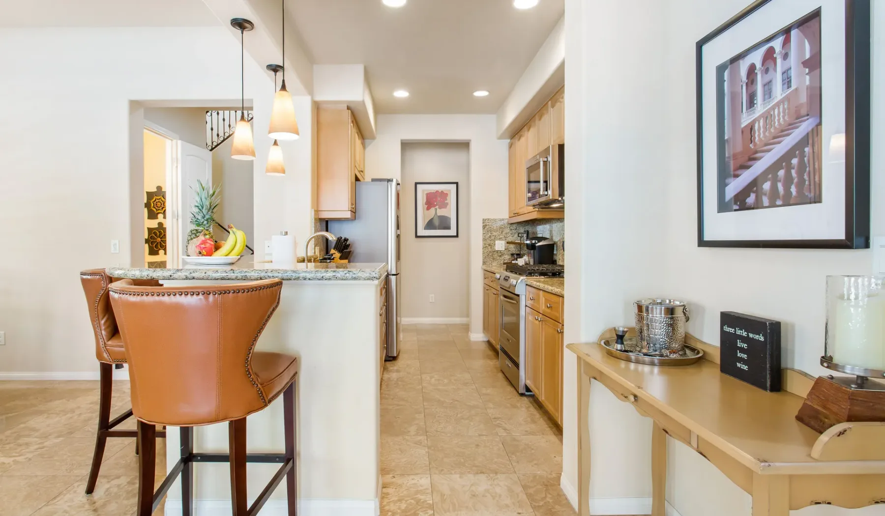 Una cocina luminosa con una barra para desayunar y una consola estrecha junto a la pared.
