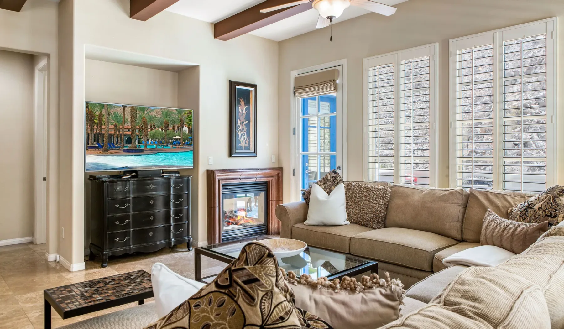 Una sala de estar con asientos, chimenea y ventanas amplias.