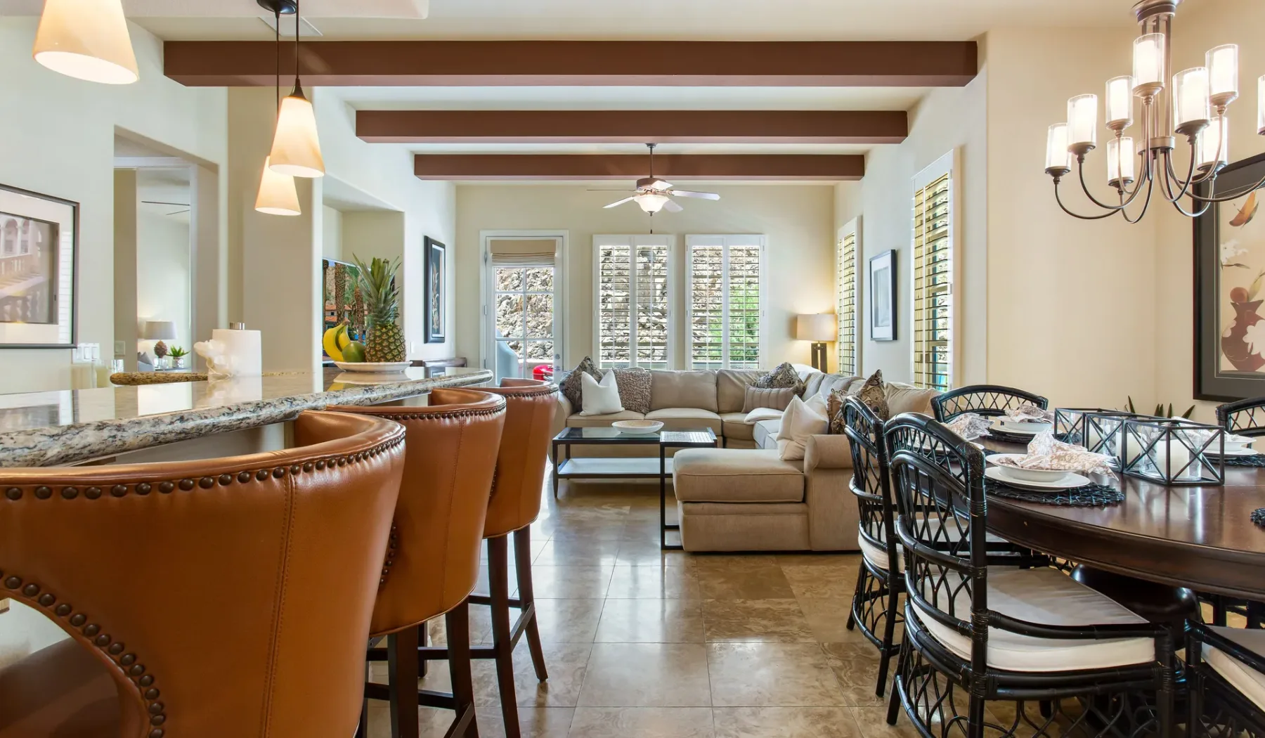 Una sala y comedor de concepto abierto con barra de cocina y asientos.