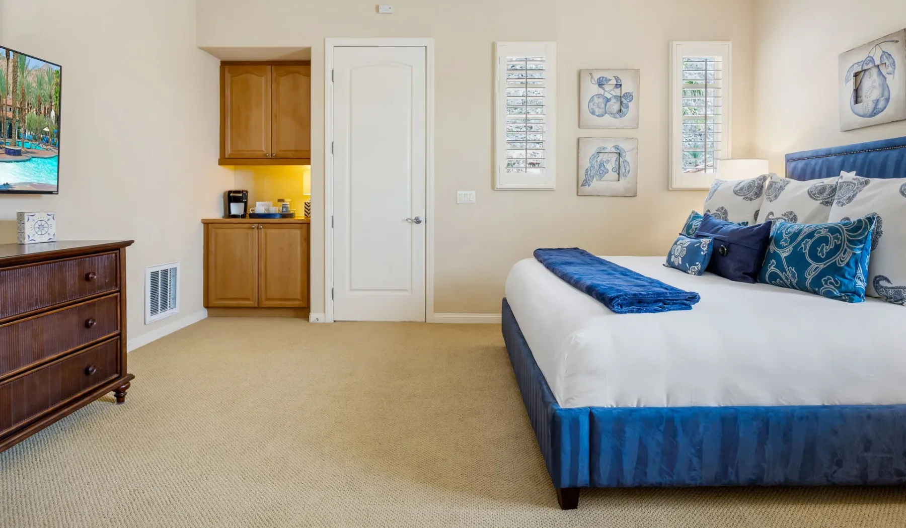 Un dormitorio con una cama vestida con ropa de cama azul y blanca.