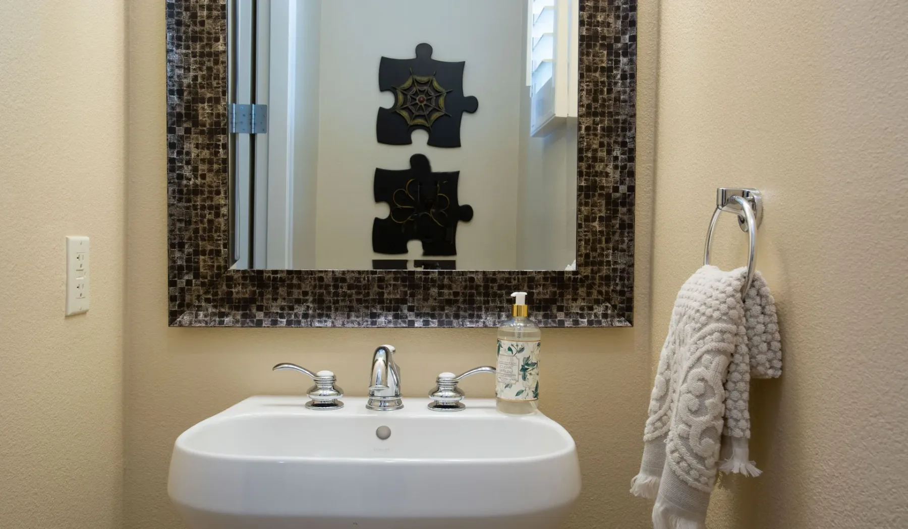 Un lavabo de baño con espejo y una toalla colgada a un lado.