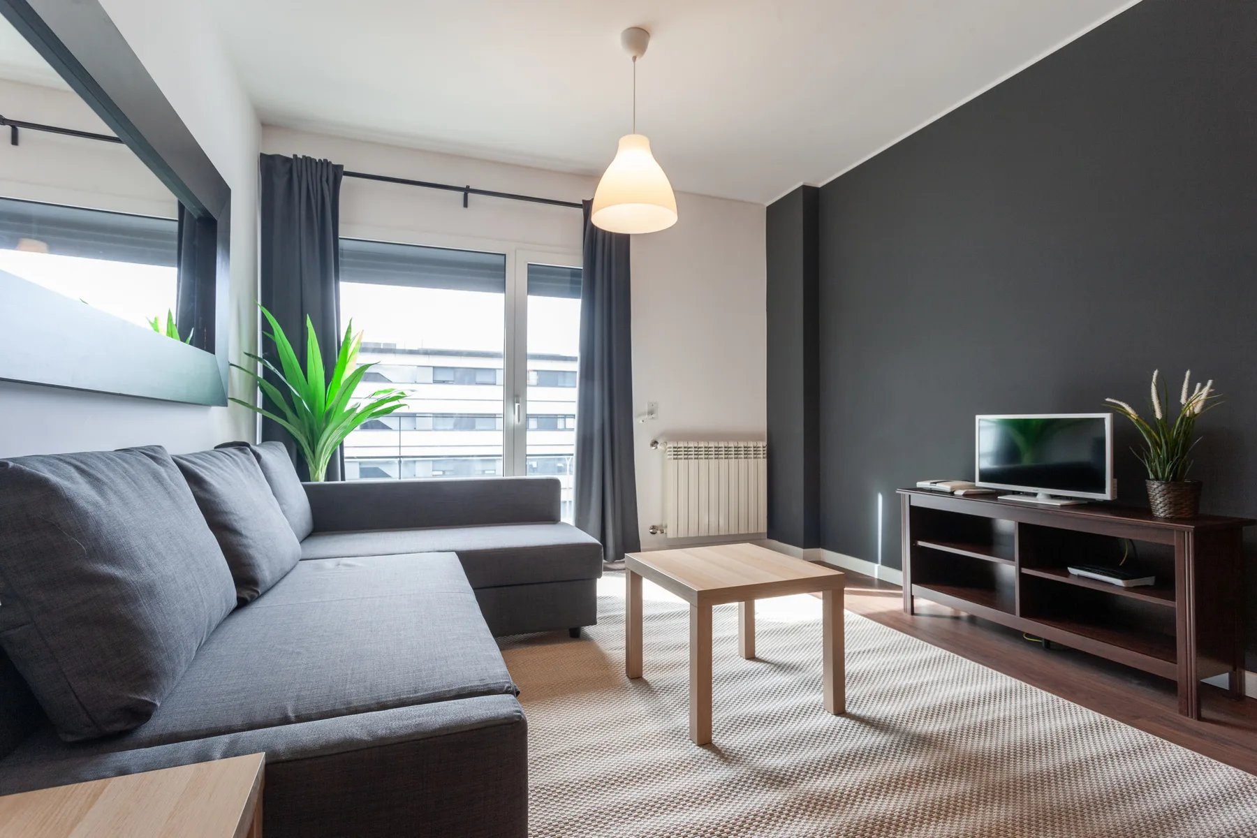 A living room with seating, a coffee table, and a television.