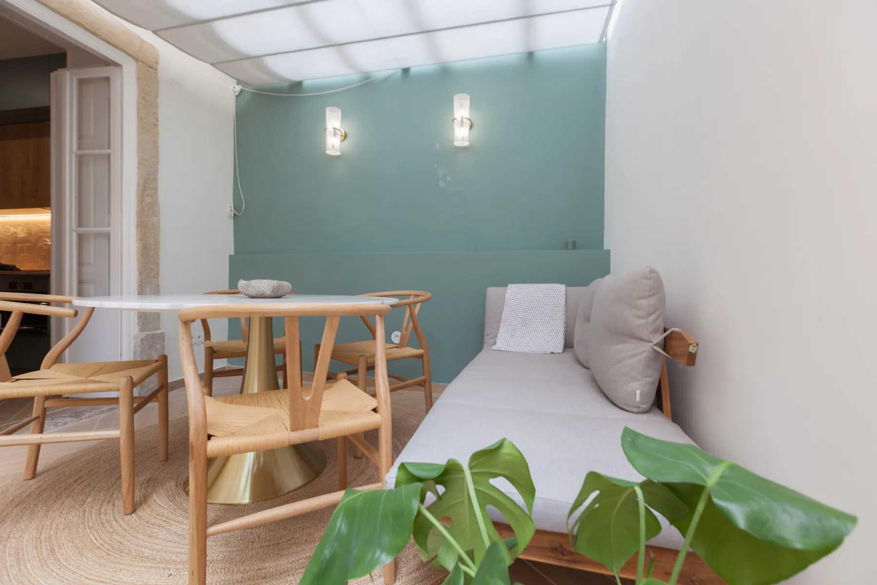 Una zona de estar luminosa con una mesa de madera junto a un diván.