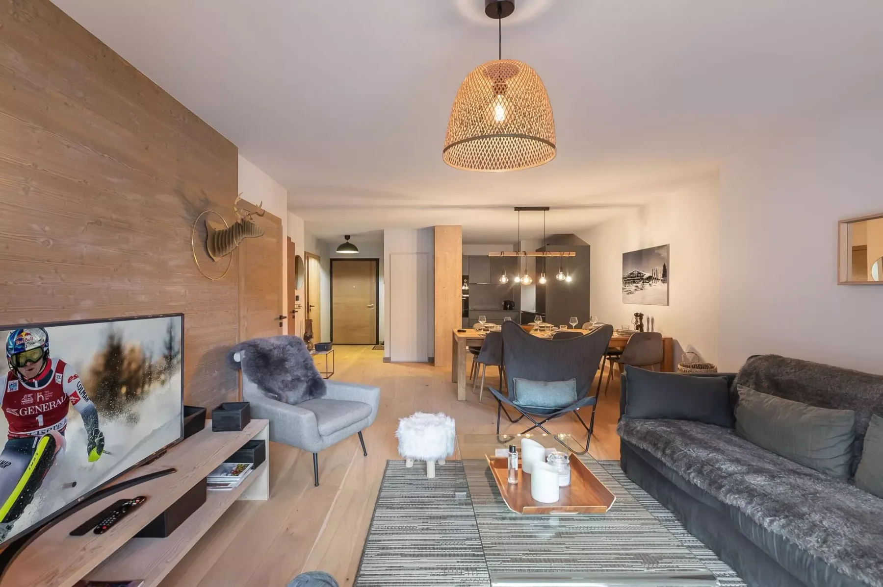 Una sala de estar con asientos alrededor de una mesa de centro y un televisor.