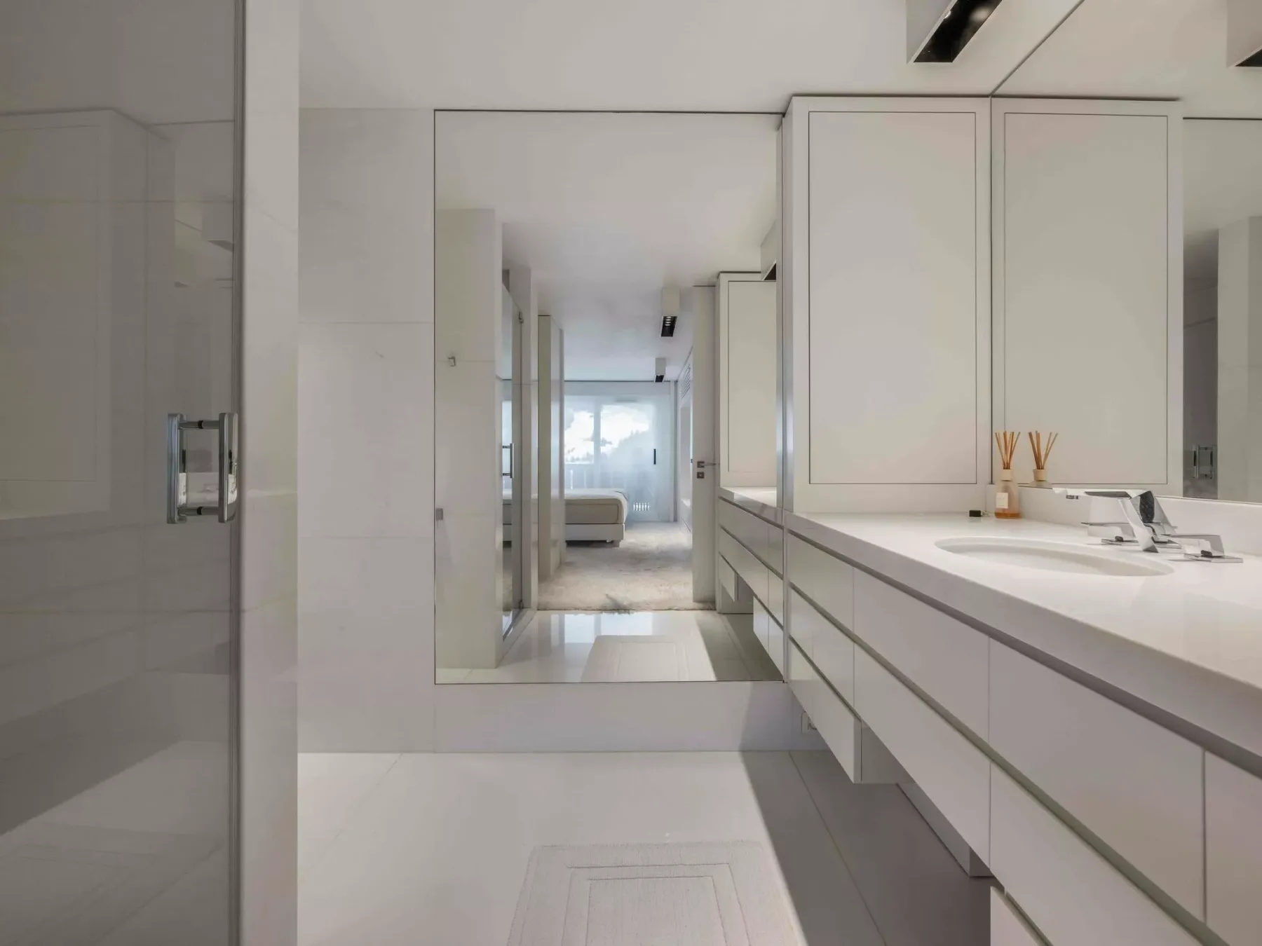Un baño luminoso con un largo tocador y un espejo grande.