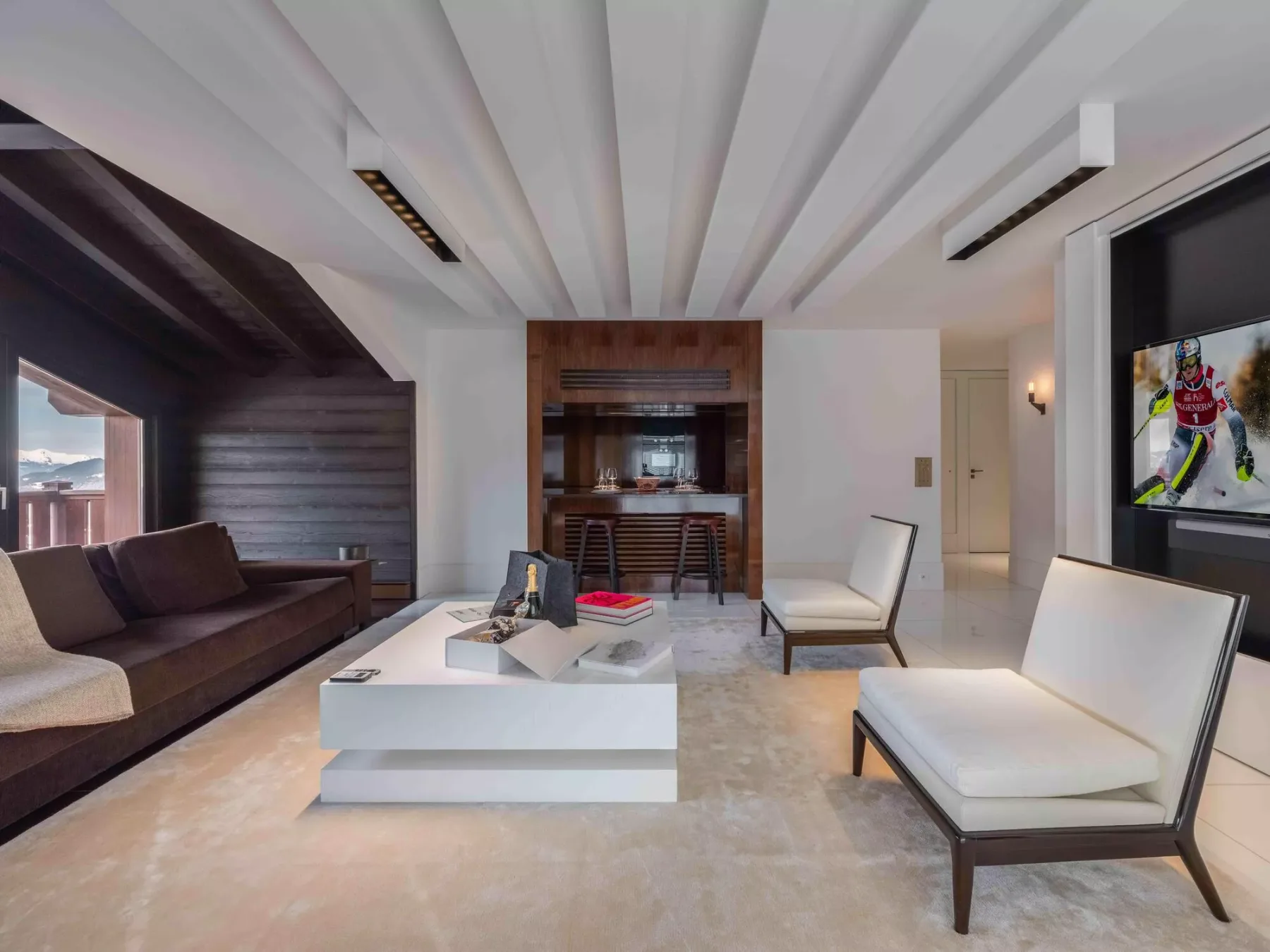 A modern living room with seating, a central coffee table, and a television.