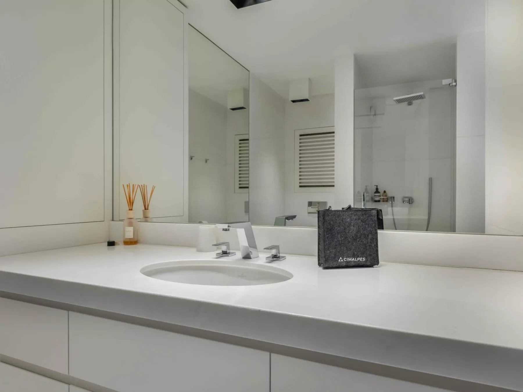 Un tocador de baño luminoso con lavabo y un espejo grande.
