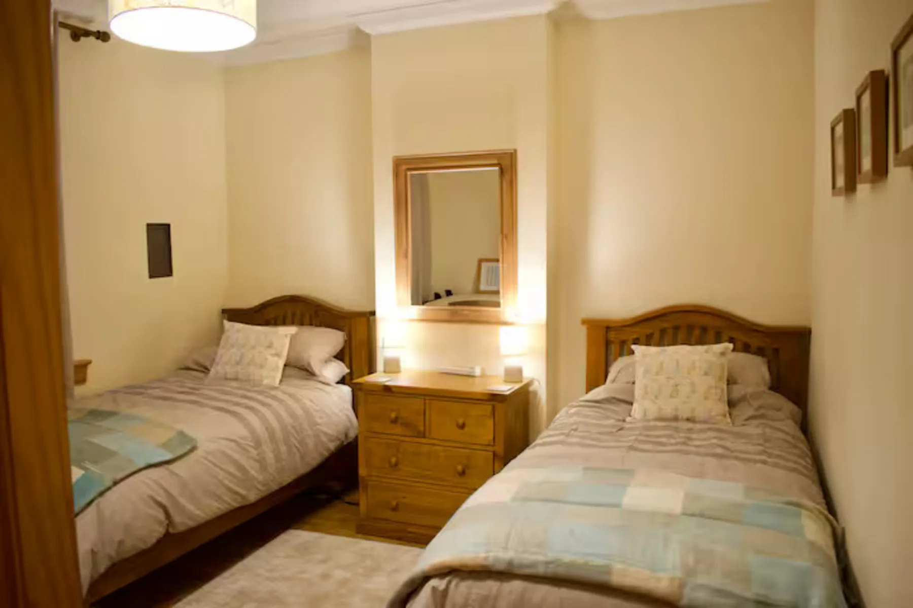Un dormitorio con dos camas y una cómoda de madera entre ellas.