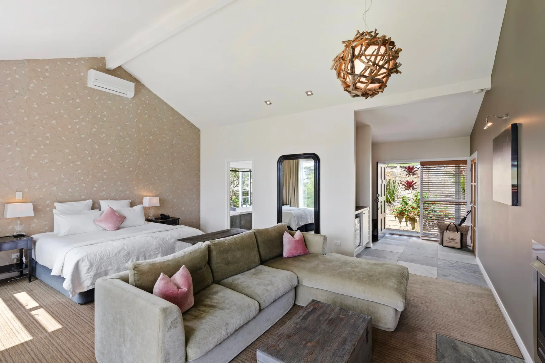 Interior de una villa con cama king, zona de estar y patio exterior.