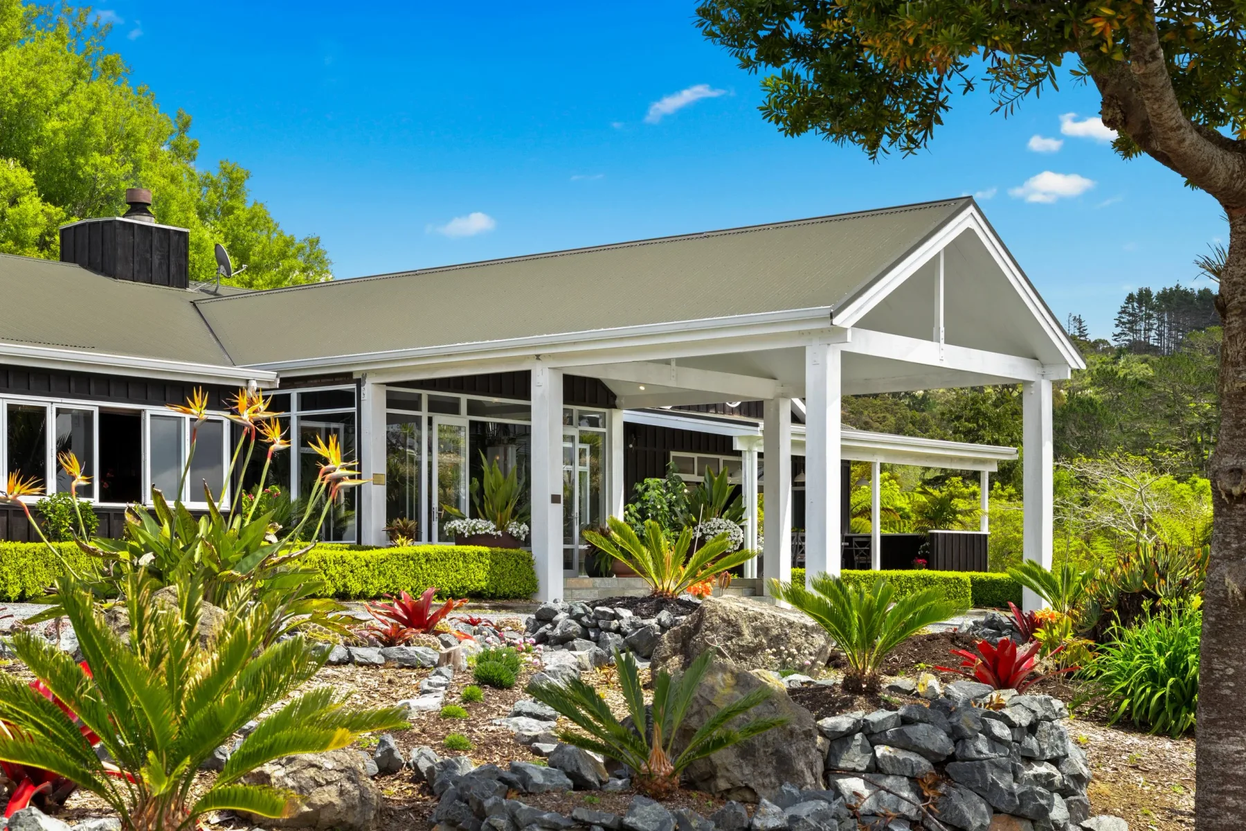 Woodhouse Mountain Lodge exterior among landscaped gardens and greenery.