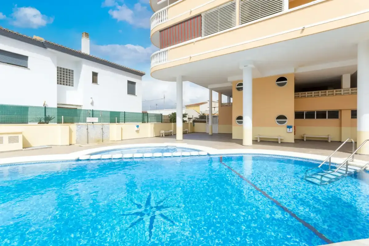 An outdoor swimming pool beside a curved building.