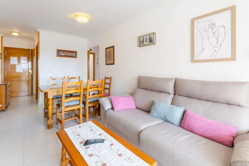 A living and dining area with a sectional sofa and wooden dining table.