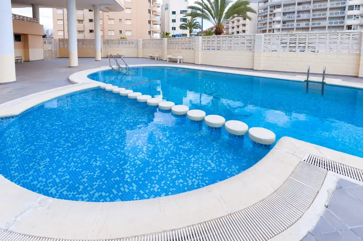 A swimming pool with a curved edge and a row of stepping stones.