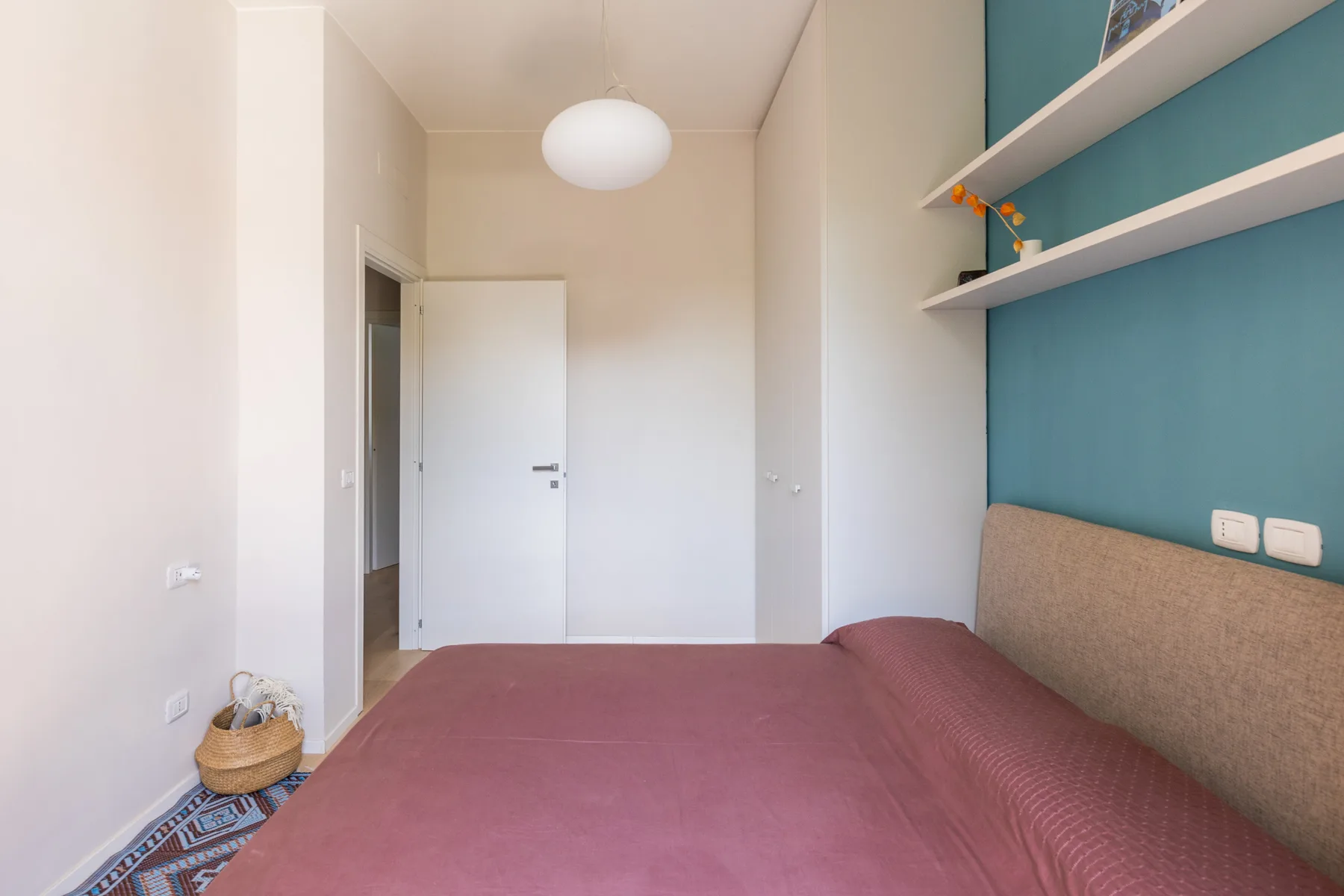 Un dormitorio con una cama debajo de estantes de pared.