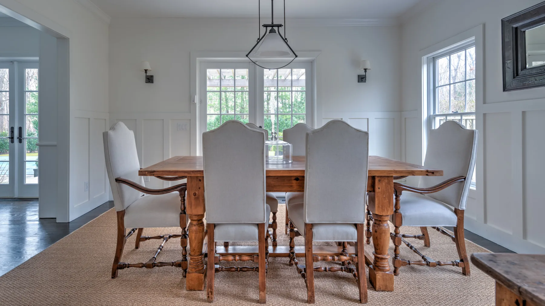 Un comedor luminoso con una mesa de madera y asientos tapizados.