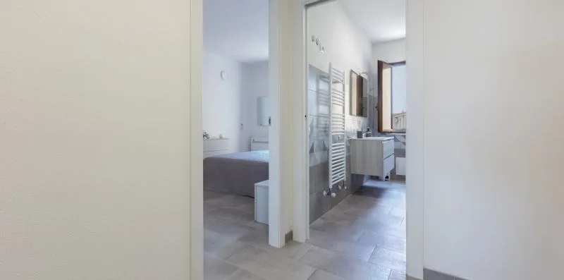 Se ven un dormitorio y un baño contiguo a través de una puerta abierta.