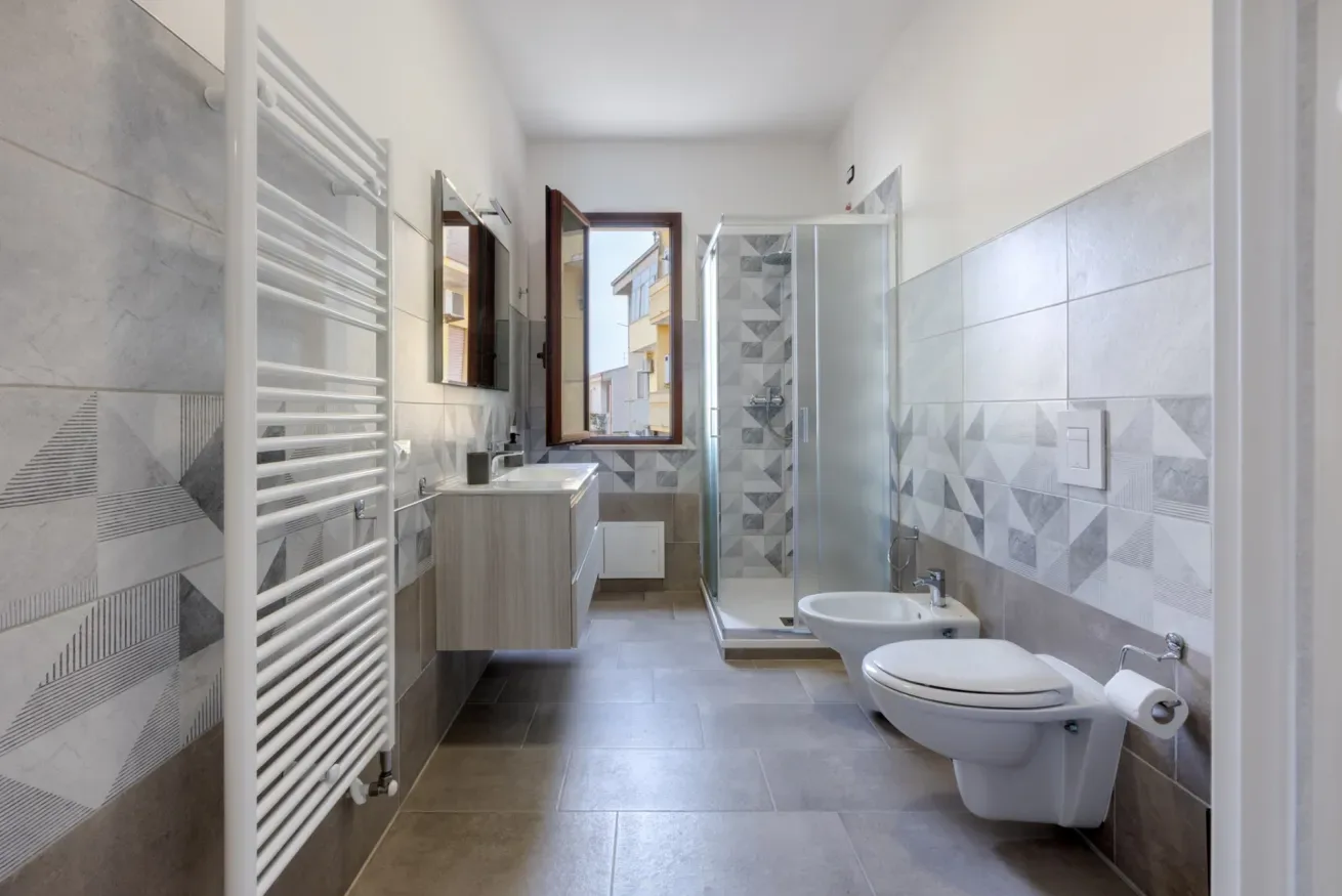 Un baño alicatado con lavabo, ducha e inodoro.