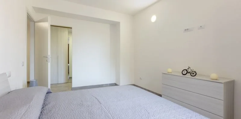 Un dormitorio con una cama y una cómoda baja junto a la pared.