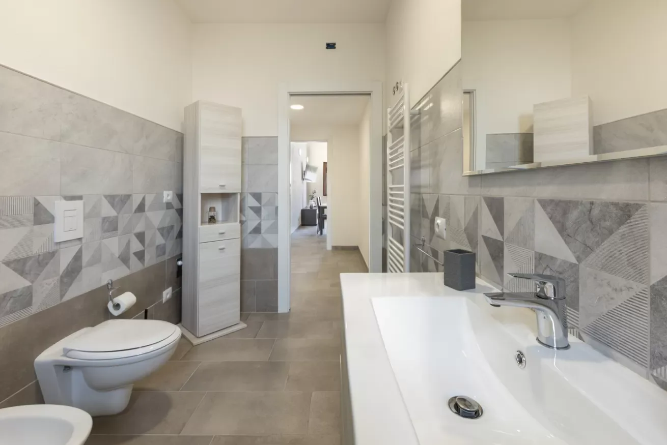 Un baño alicatado con bañera, lavabo e inodoro.