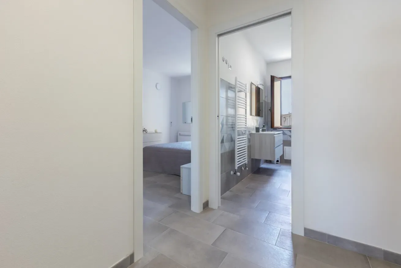 Un baño con lavabo y toallero, visto a través de una puerta.