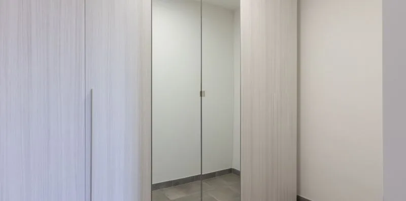Un pasillo con una puerta cerrada y paredes de tonos claros.