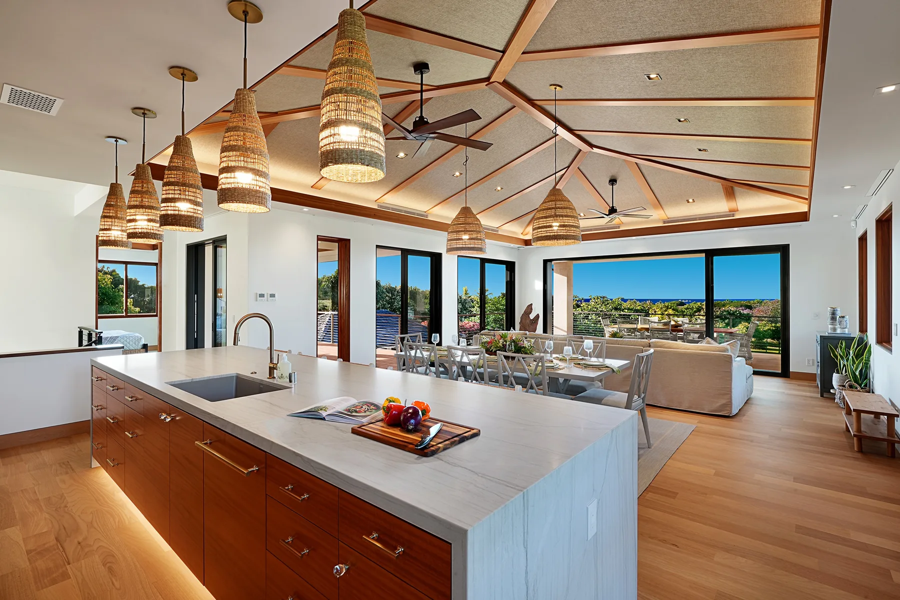 Una cocina abierta a la sala tiene una isla grande y amplias ventanas.