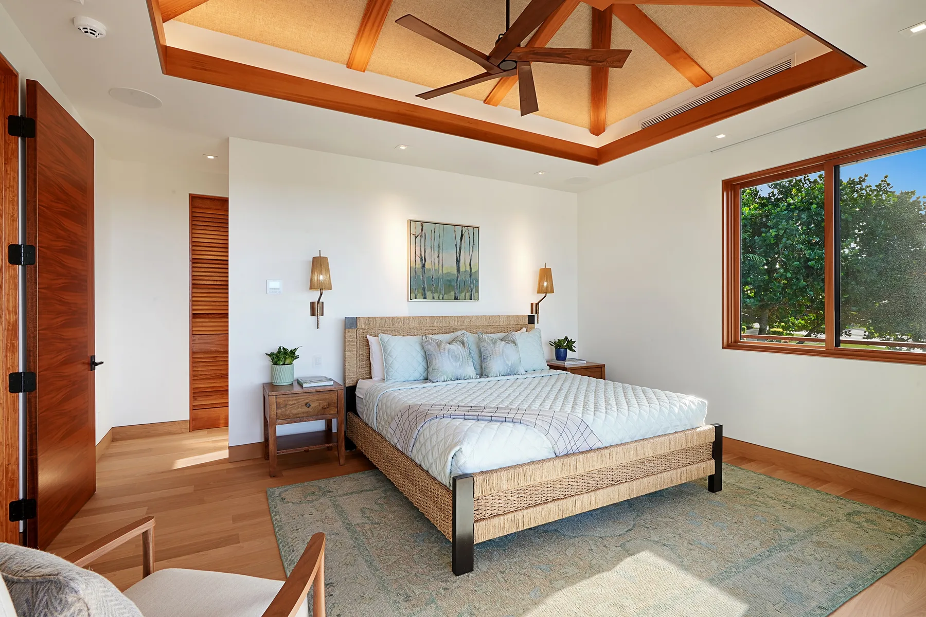 Un dormitorio luminoso con una cama bajo un techo con vigas de madera.