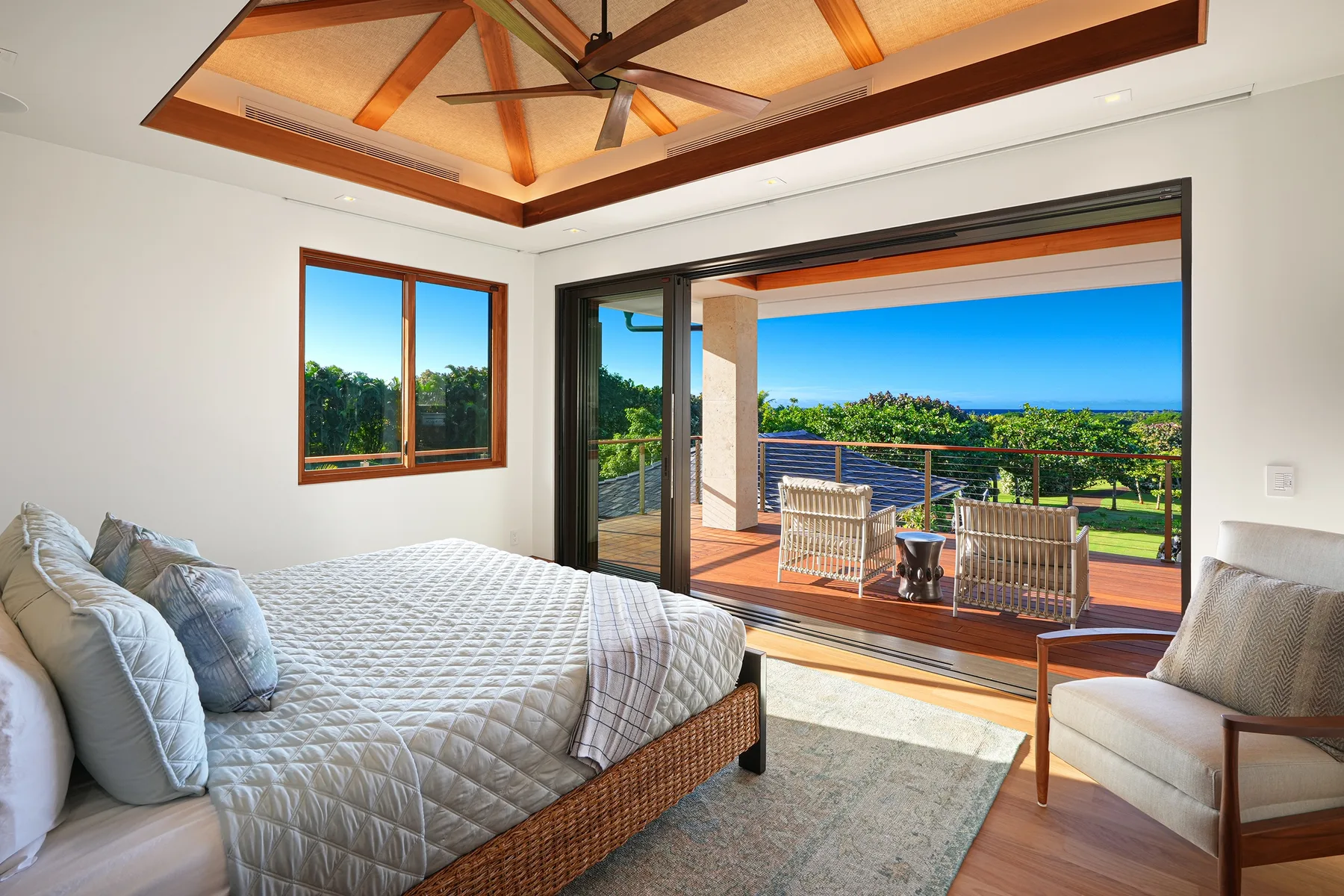 Un dormitorio luminoso da a una terraza cubierta con vistas al océano.