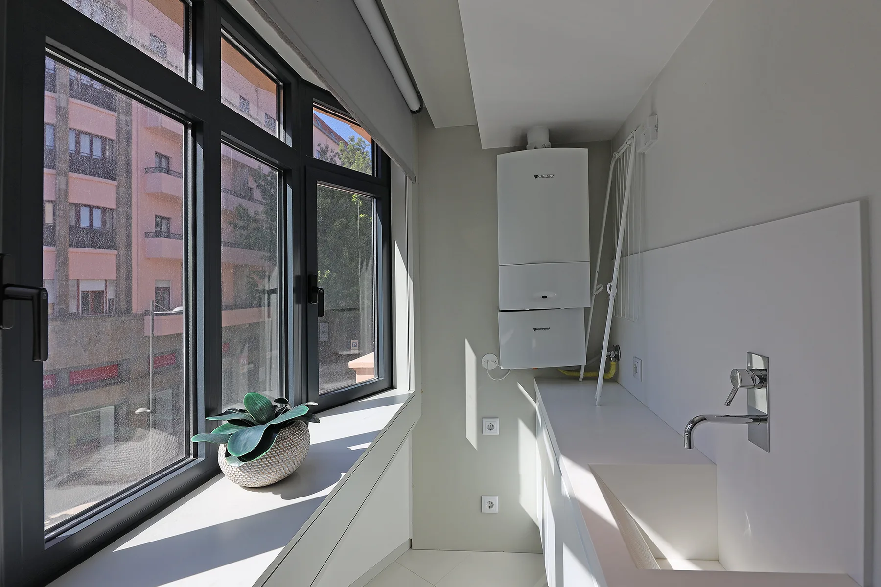 A bright utility room with a sink and large windows.