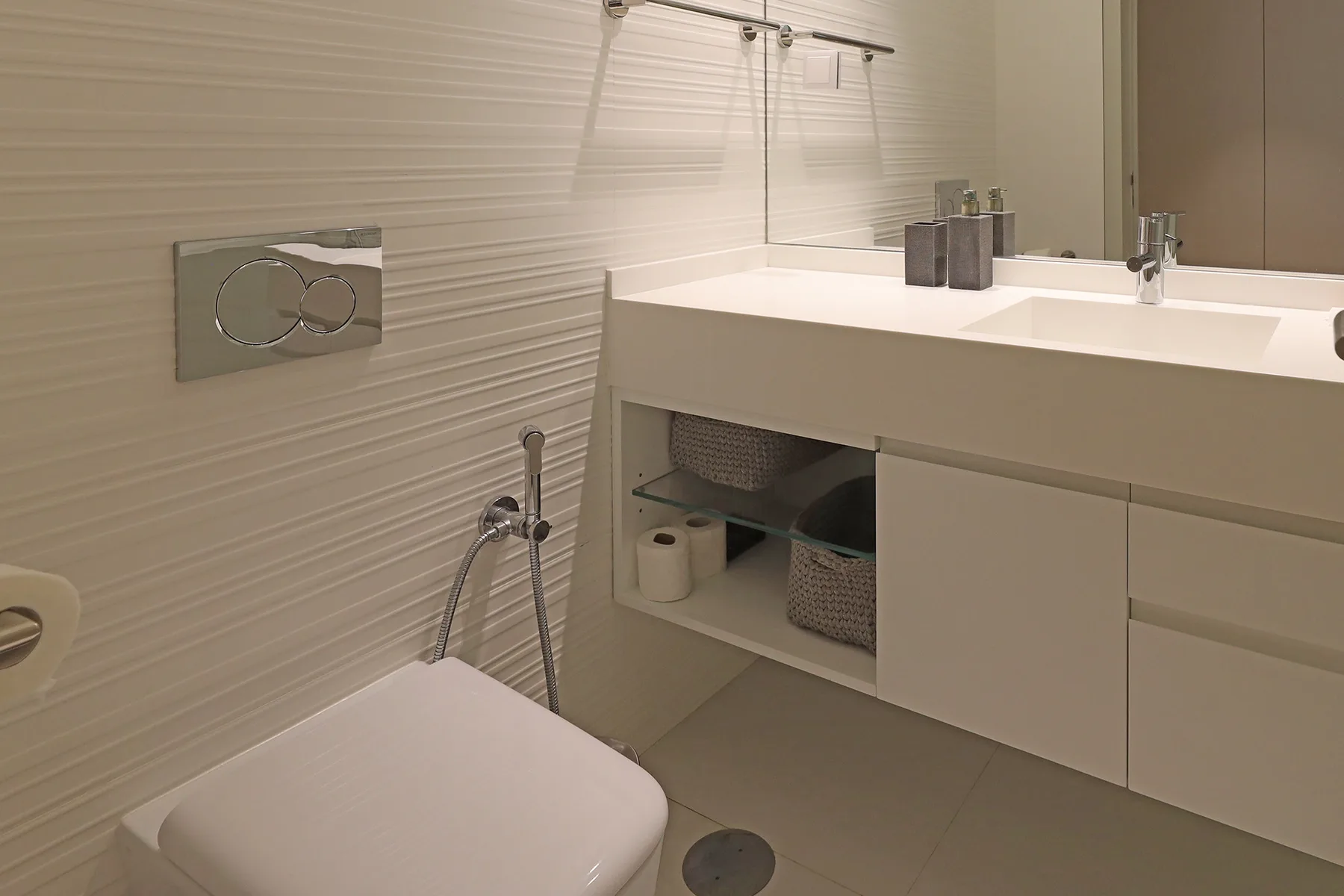 A modern bathroom with a white vanity and toilet.