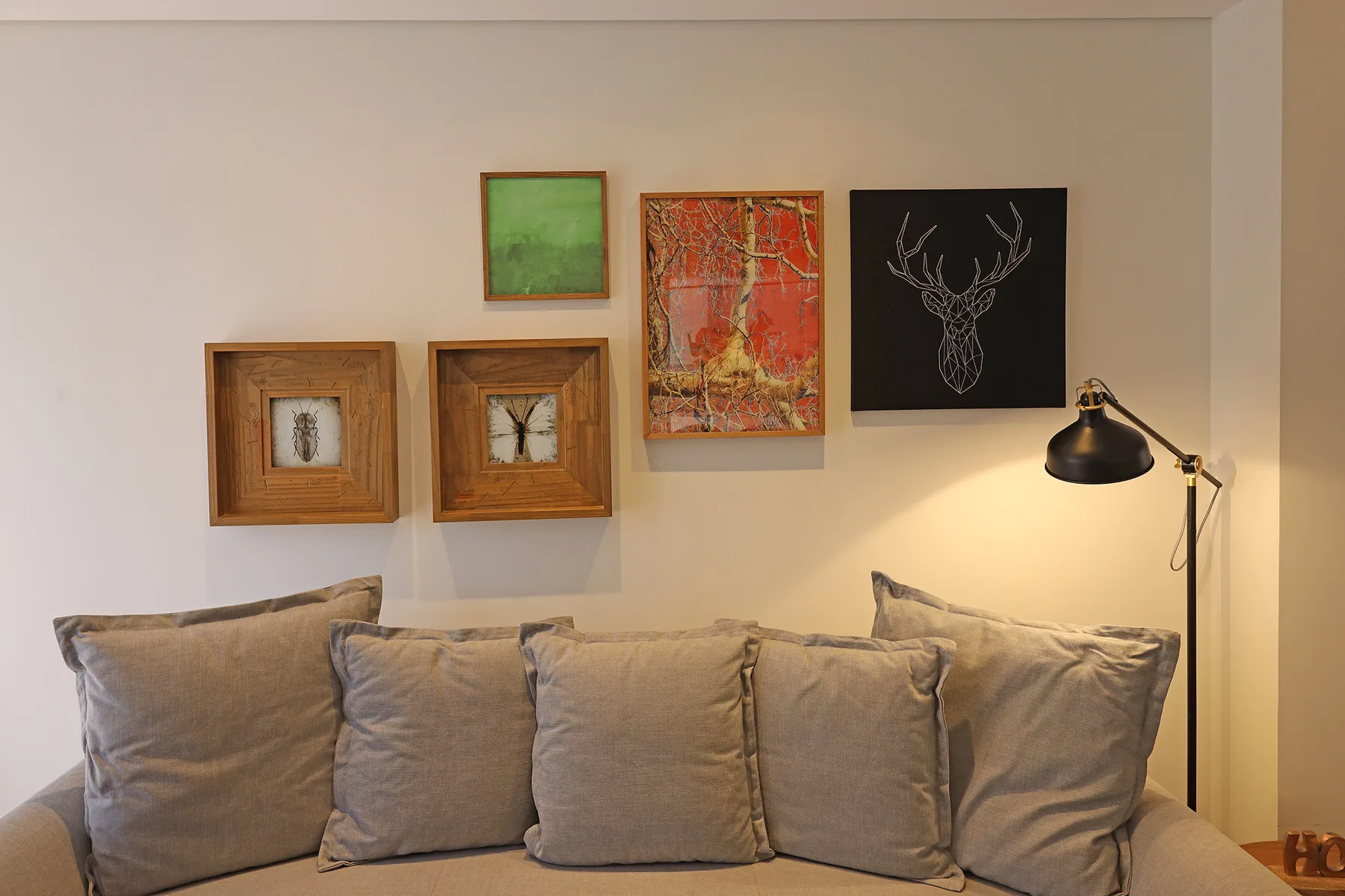 A living room with a beige sofa and framed artwork on the wall.