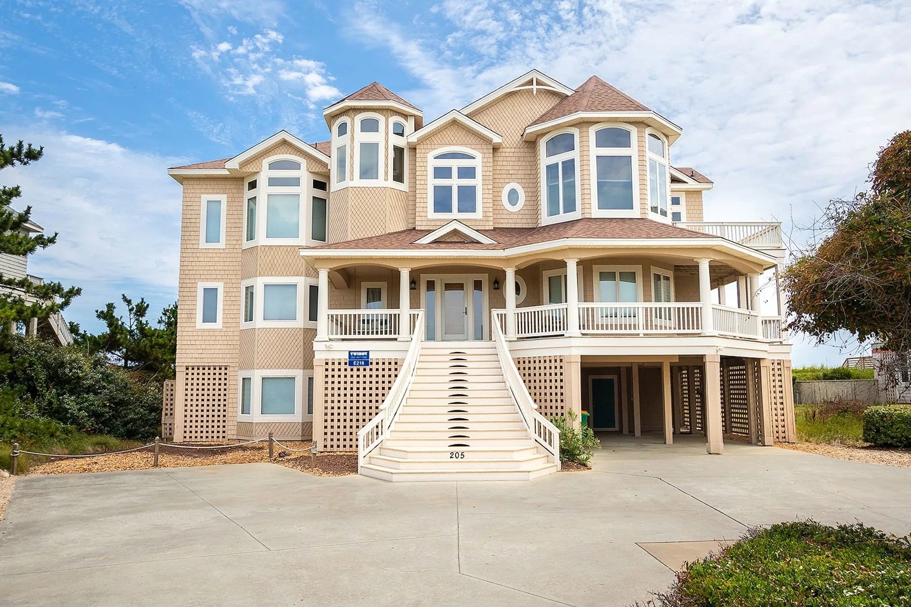 A large coastal-style house with a broad front staircase and covered porch.