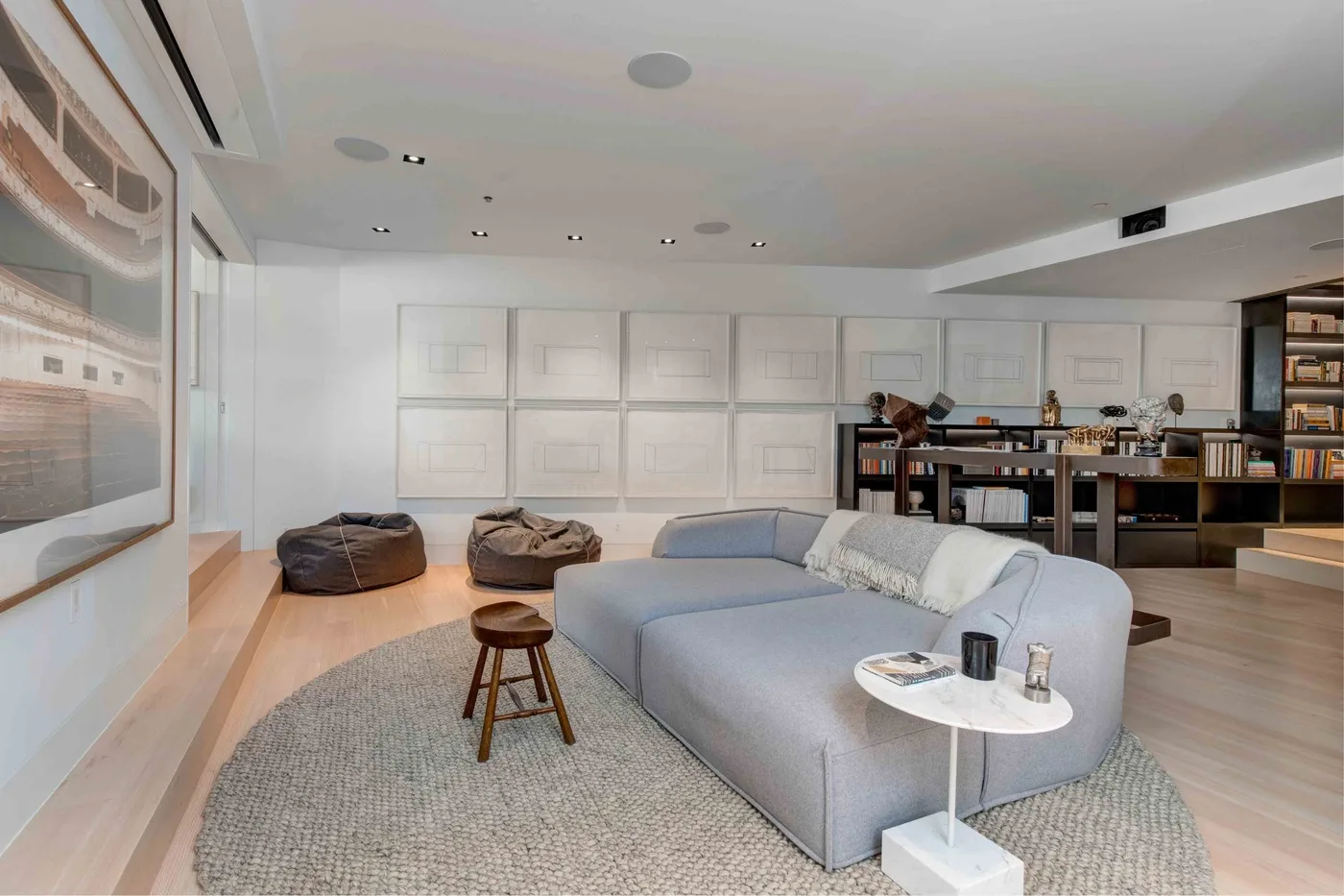 A modern living room with a gray seating area and a rug.